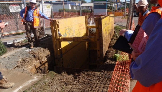Site team reviewing plans beside an excavation